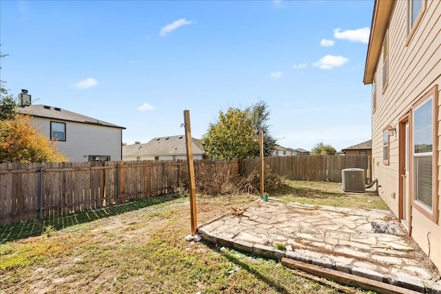 view of yard with central air condition unit and a patio area