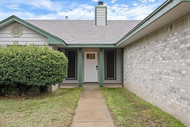 entrance to property featuring a yard