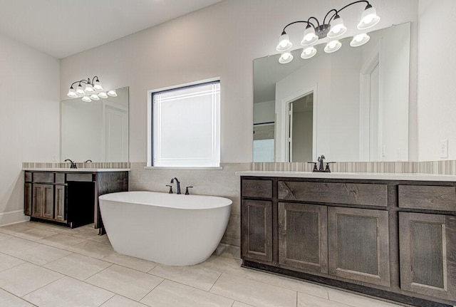 bathroom featuring tile patterned floors, vanity, a bath, and tile walls