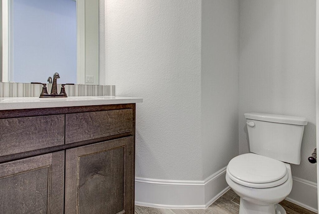 bathroom with hardwood / wood-style floors, vanity, and toilet