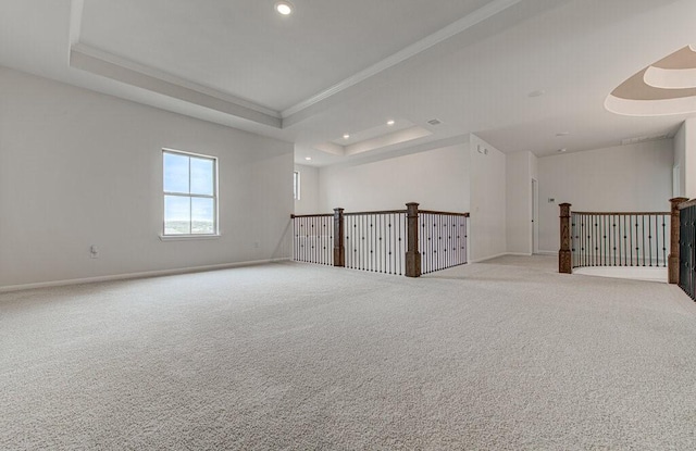 unfurnished room with light carpet and a tray ceiling