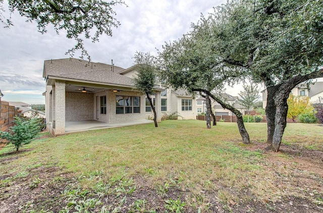 back of house featuring ceiling fan, a patio area, and a lawn