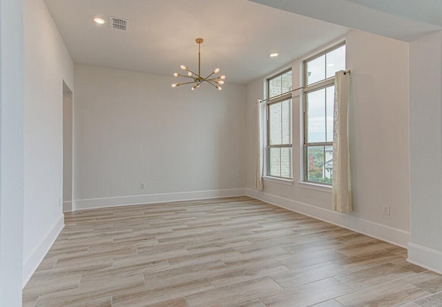 unfurnished room featuring light wood-type flooring and a chandelier