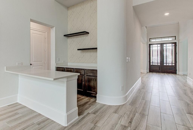 interior space with dark brown cabinetry, light hardwood / wood-style flooring, and french doors