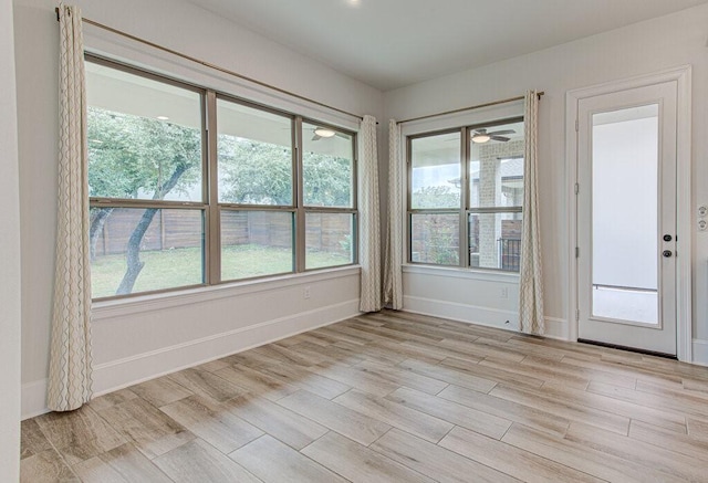 unfurnished room with a wealth of natural light and light hardwood / wood-style flooring