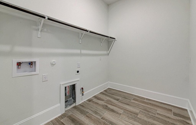 clothes washing area with washer hookup, hardwood / wood-style floors, hookup for a gas dryer, and electric dryer hookup