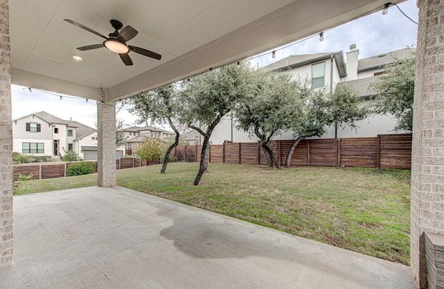 view of yard with ceiling fan and a patio area