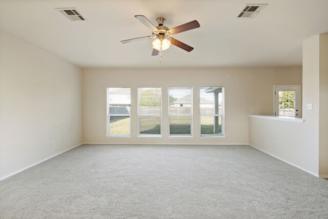 unfurnished room featuring plenty of natural light, ceiling fan, and light colored carpet