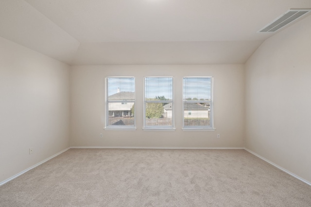 carpeted empty room featuring a healthy amount of sunlight and lofted ceiling