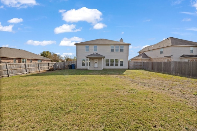 back of house featuring a lawn