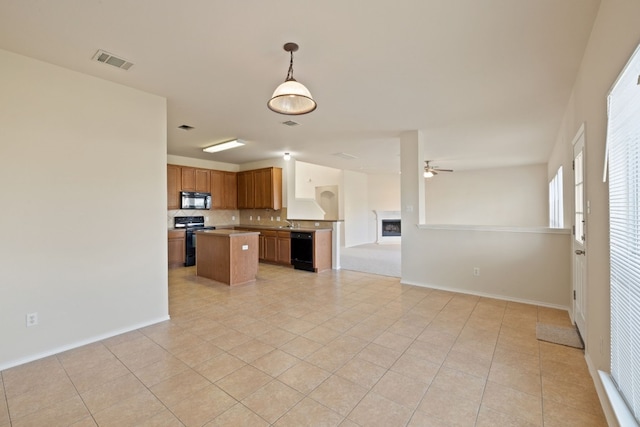 kitchen featuring a center island, pendant lighting, decorative backsplash, light tile patterned floors, and black appliances