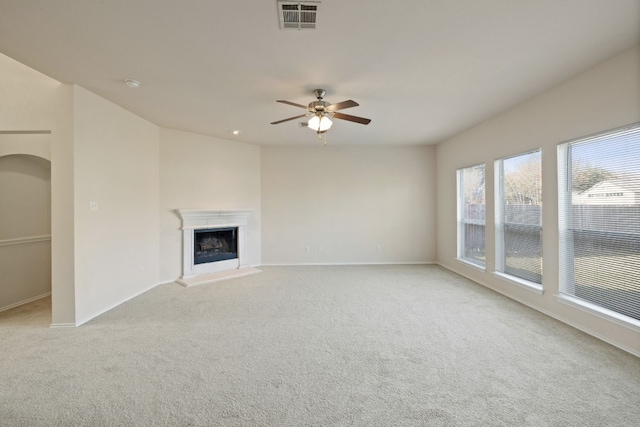 unfurnished living room featuring ceiling fan and light carpet