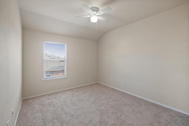 carpeted spare room with vaulted ceiling and ceiling fan