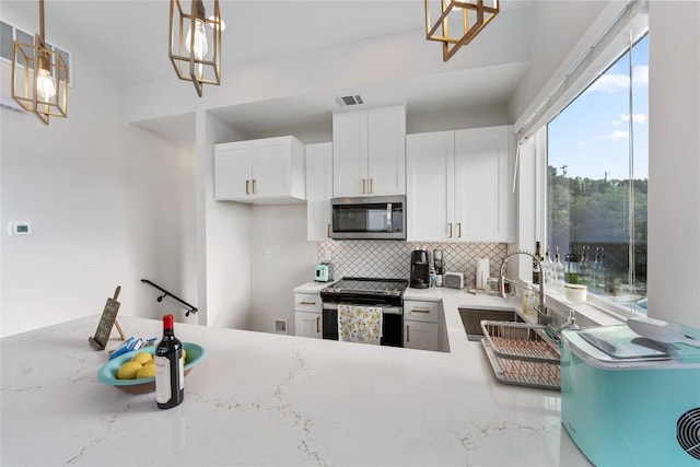 kitchen featuring decorative backsplash, appliances with stainless steel finishes, sink, decorative light fixtures, and white cabinetry