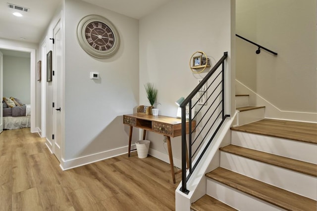 staircase with hardwood / wood-style flooring