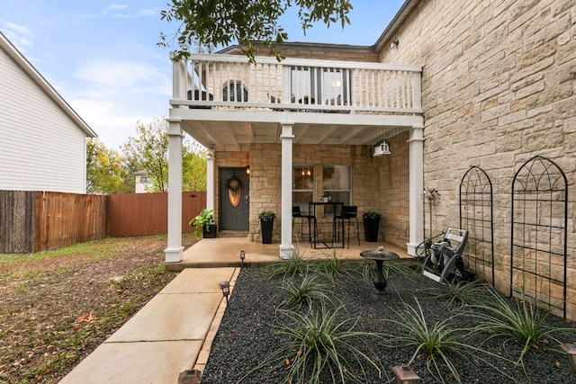 back of house featuring a balcony and a patio