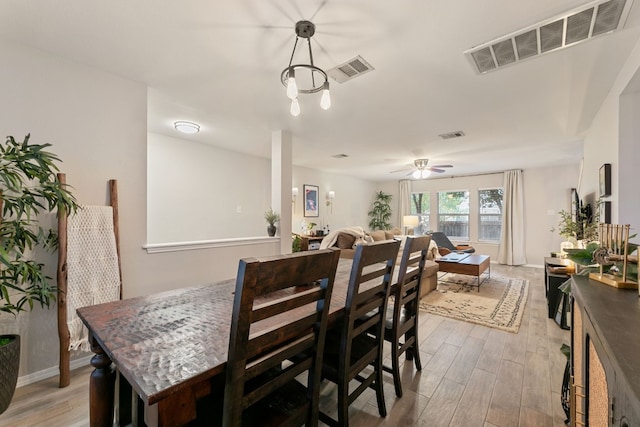 dining space with ceiling fan and light hardwood / wood-style floors