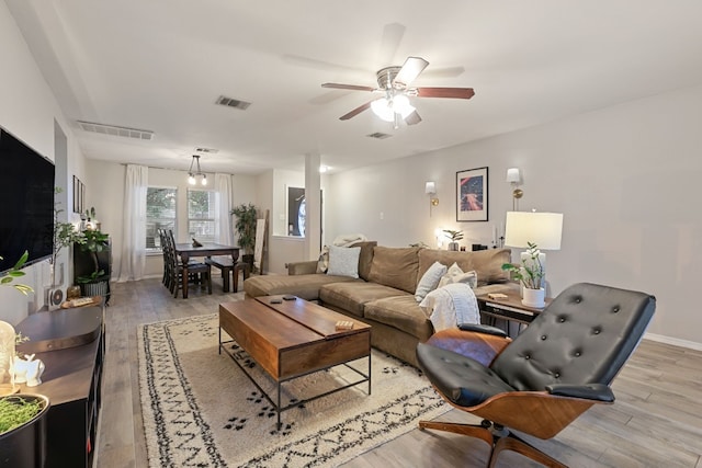 living room featuring light hardwood / wood-style floors and ceiling fan