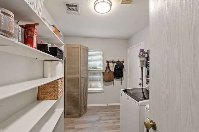 washroom with separate washer and dryer and light wood-type flooring