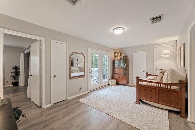 bedroom with access to exterior and hardwood / wood-style flooring