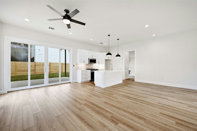 unfurnished living room featuring light hardwood / wood-style flooring, ceiling fan, and sink