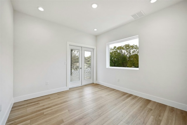 unfurnished room with french doors and light hardwood / wood-style flooring