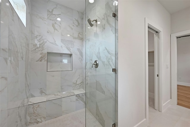 bathroom with tile patterned flooring and tiled shower