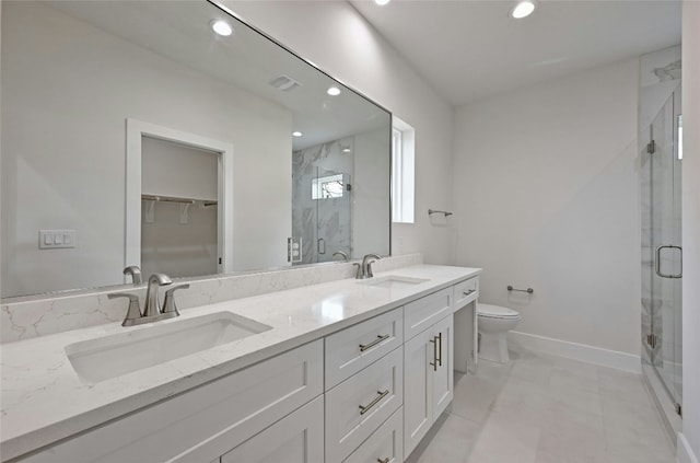 bathroom featuring tile patterned floors, vanity, a shower with shower door, and toilet