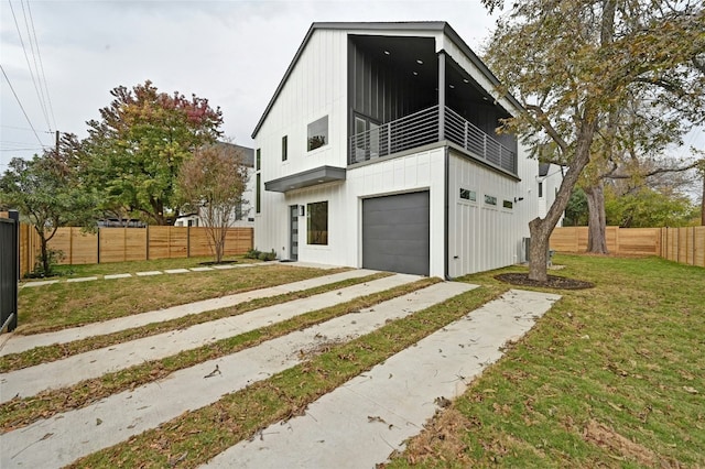 102 W Fawnridge Dr, Austin, TX 78753 - view of front of house featuring a balcony, board and batten siding, a garage, driveway, and a fenced backyard