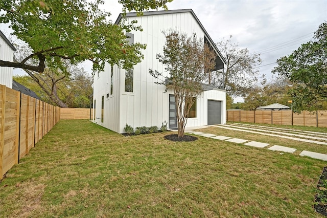 102 W Fawnridge Dr, Austin, TX 78753 - back of property featuring a lawn, board and batten siding, a detached garage, and a fenced backyard