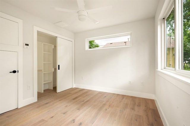 unfurnished room featuring light wood-type flooring, ceiling fan, and a healthy amount of sunlight