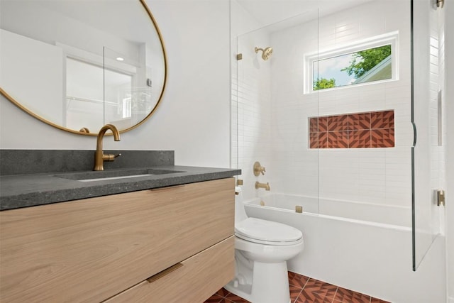 full bathroom with toilet, vanity, and tiled shower / bath