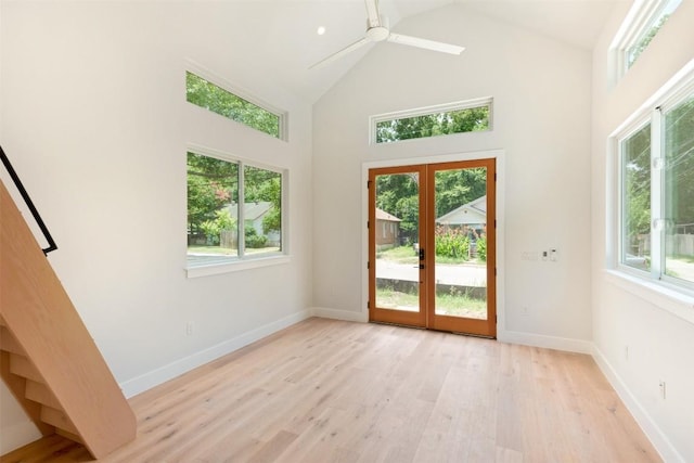 entryway featuring french doors, light hardwood / wood-style floors, high vaulted ceiling, and plenty of natural light