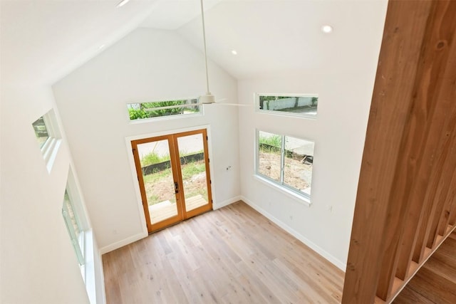 interior space with light hardwood / wood-style flooring, high vaulted ceiling, and french doors