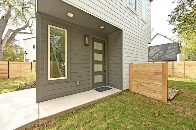 view of exterior entry with a yard