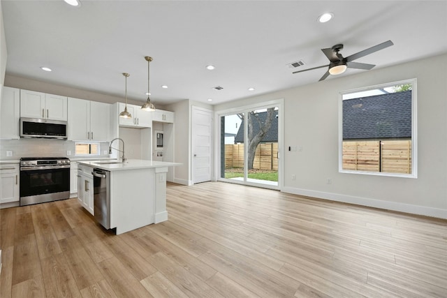 kitchen featuring appliances with stainless steel finishes, ceiling fan, sink, pendant lighting, and white cabinetry