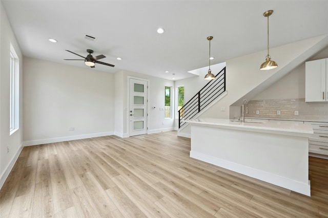 9104 Georgian Dr, Austin, TX 78753 - unfurnished living room featuring stairs, a ceiling fan, light wood-style flooring, and recessed lighting