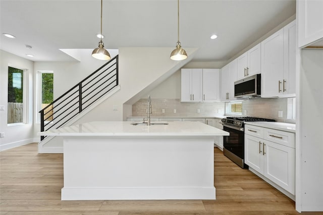 kitchen featuring white cabinets, pendant lighting, sink, and stainless steel appliances