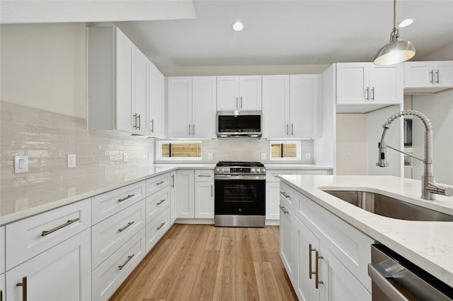 9104 Georgian Dr, Austin, TX 78753 - kitchen with appliances with stainless steel finishes, white cabinetry, light stone countertops, recessed lighting, and light wood-style floors