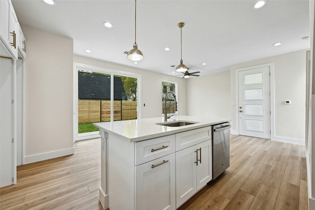 9104 Georgian Dr, Austin, TX 78753 - kitchen with dishwasher, light wood finished floors, white cabinets, light countertops, and hanging light fixtures