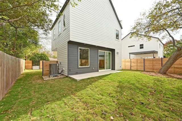 rear view of house featuring a yard, cooling unit, and a patio area