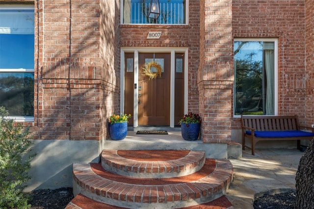 doorway to property featuring brick siding