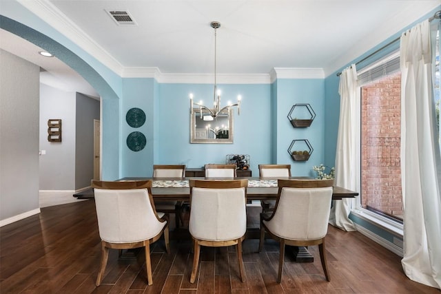 dining area featuring dark hardwood / wood-style flooring, a chandelier, and ornamental molding