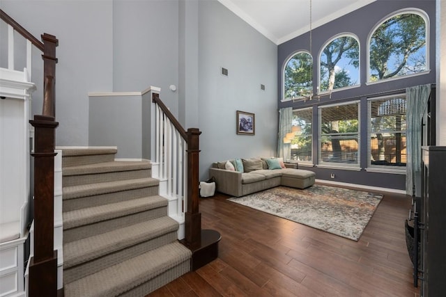 living room featuring dark hardwood / wood-style flooring, high vaulted ceiling, and crown molding