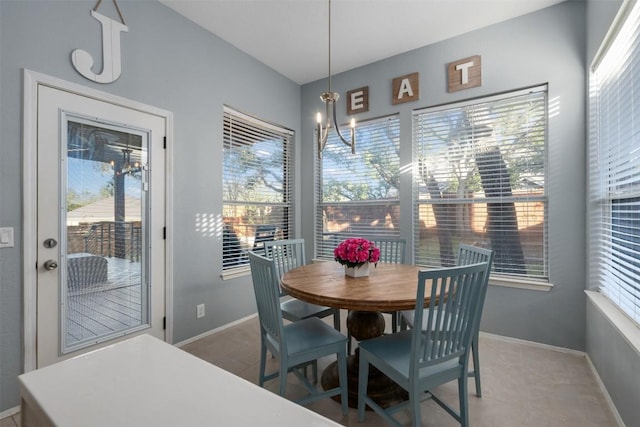 dining space featuring baseboards and an inviting chandelier