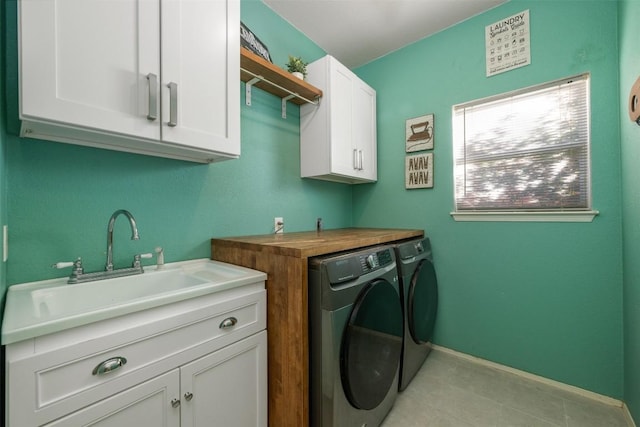 laundry area with washer and clothes dryer, cabinets, light tile patterned floors, and sink