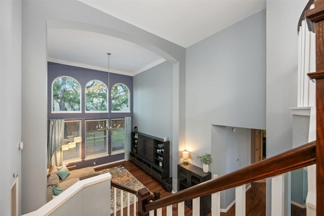 living room featuring dark hardwood / wood-style flooring, ornamental molding, and an inviting chandelier