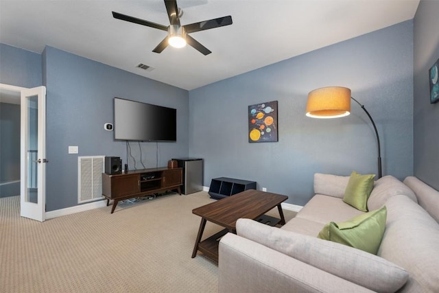 living room featuring light carpet, french doors, and ceiling fan