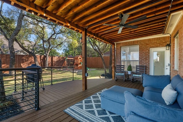 wooden deck featuring a playground and ceiling fan