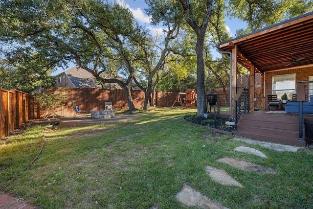 view of yard featuring a playground, a wooden deck, and ceiling fan